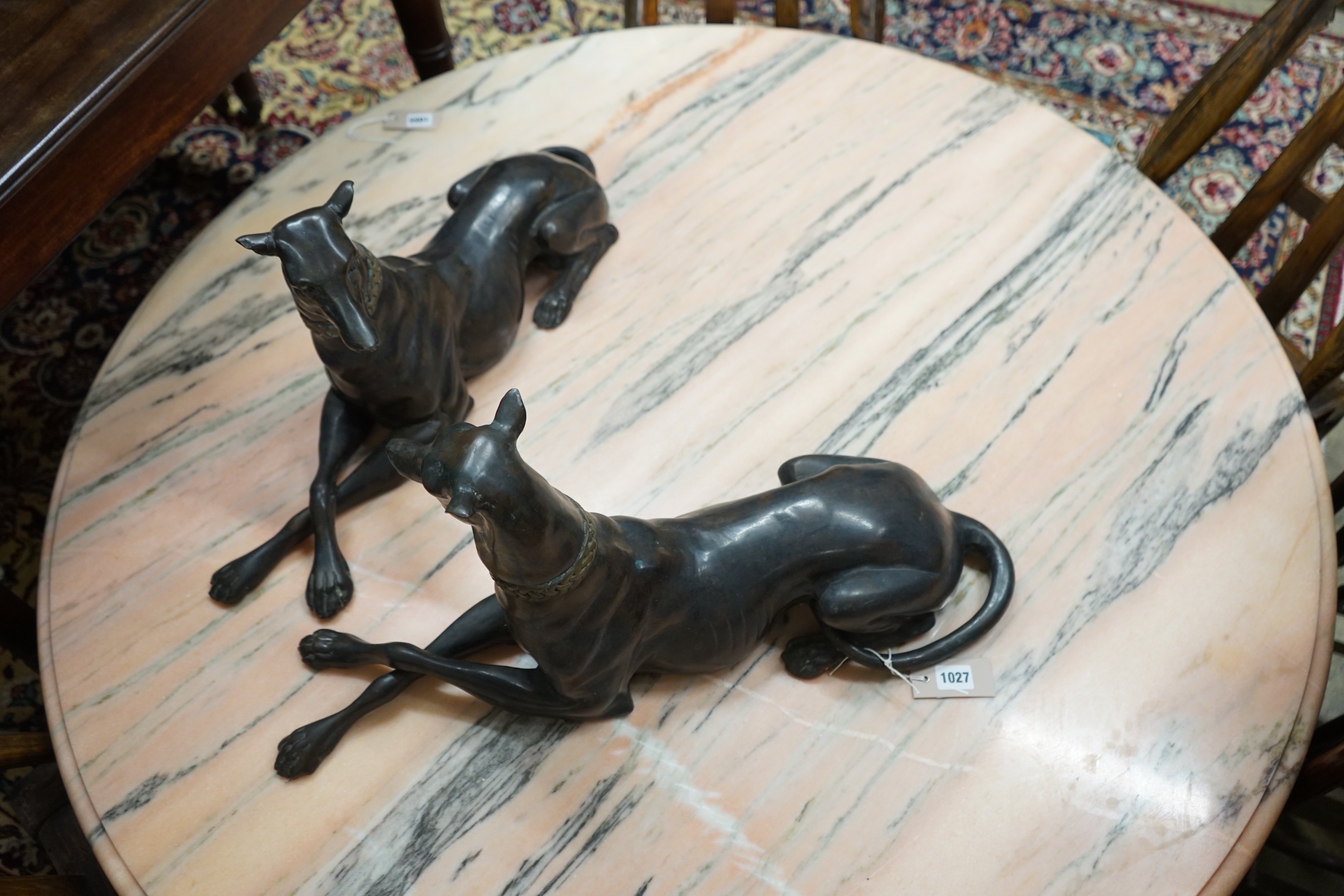 A pair of bronze recumbent greyhounds, length 67cm, height 32cm